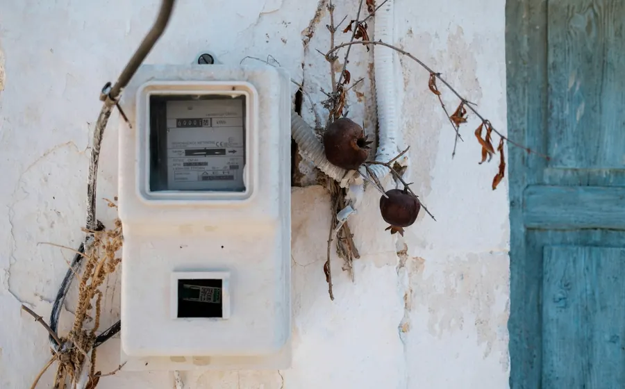 Medidor eléctrico antiguo en un muro blanco